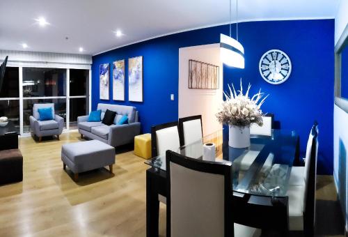 a living room with a blue wall and a dining room at GL Apts, rent Upper Pardo Miraflores - Suite 1 Hab in Lima