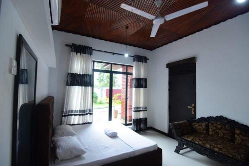 ラトゥナプラにあるCHANA BRICKS BUNGALOWのリビングルーム(ベッド1台、天井ファン付)