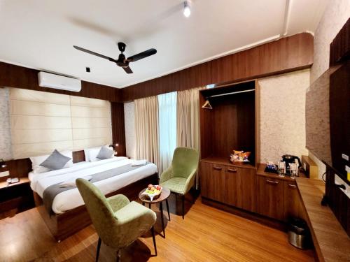 シュリーナガルにあるHotel Royal Plazaのベッド、デスク、椅子が備わるホテルルームです。