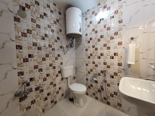 a bathroom with a toilet and a sink at Hotel Royal Plaza in Srinagar