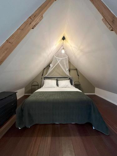 um quarto com uma cama num sótão em Boutique appartement vlak bij Amsterdam em Rijnsaterwoude