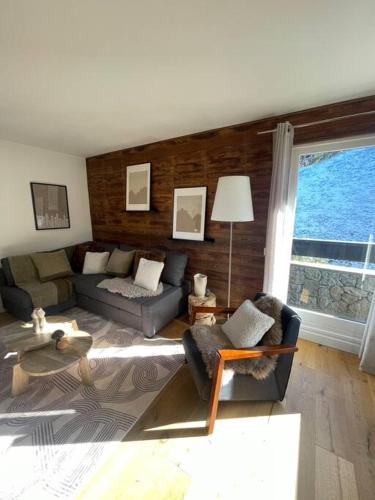 a living room with a couch and a table at Le LihamWood in Megève