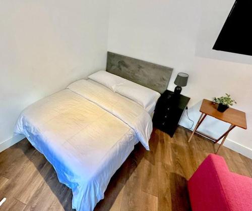 een slaapkamer met een wit bed en een tafel bij 1. VE Central Studio - 100m to Piccadilly Circus! in Londen