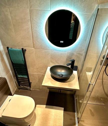 een badkamer met een wastafel, een toilet en een spiegel bij 1. VE Central Studio - 100m to Piccadilly Circus! in Londen