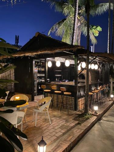 a restaurant with chairs and tables and a bar at Fides Boutique Hotel in Luang Prabang