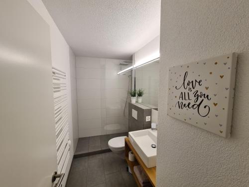 ein Badezimmer mit WC und ein Schild, auf dem steht: Live all star mixt in der Unterkunft Haus Allod 205 in Lenzerheide