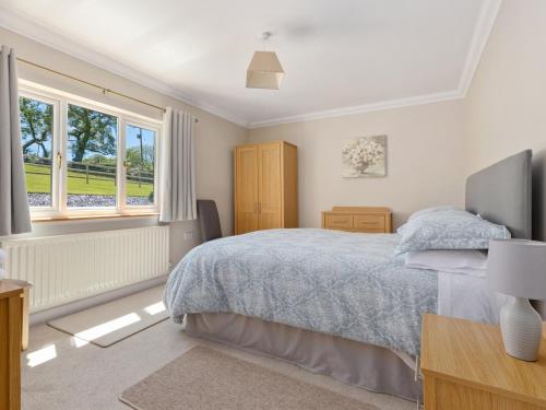 a bedroom with a bed and a window at Highgrove in Narberth