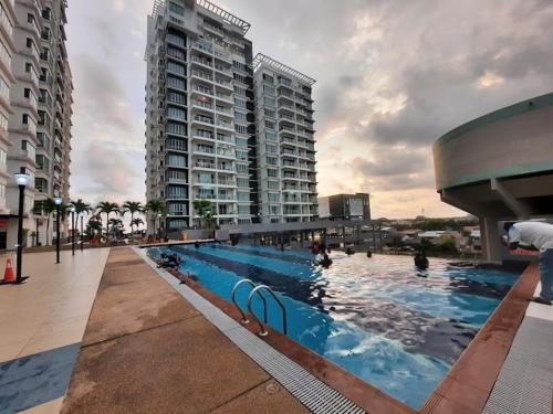 a large swimming pool in a city with tall buildings at Best Sekinchan homestay in Sekincan