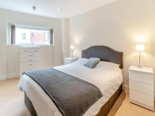 a bedroom with a large bed and a window at Apartment 13 in Swansea