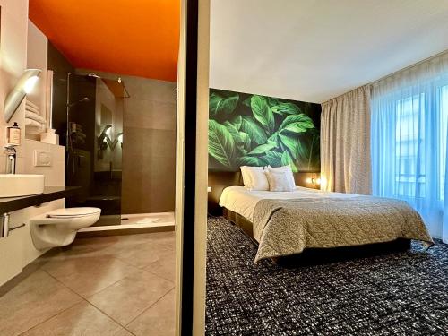 a hotel room with a bed and a bathroom at La Paix Hôtel Contemporain Brest centre ville in Brest