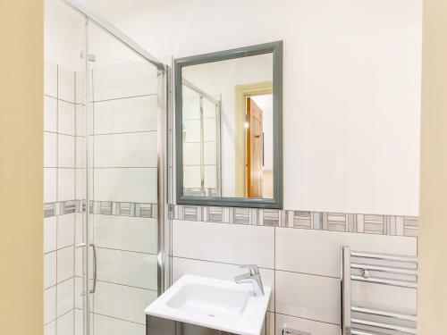 a bathroom with a sink and a mirror at Graydon Cottage in Wigglesworth