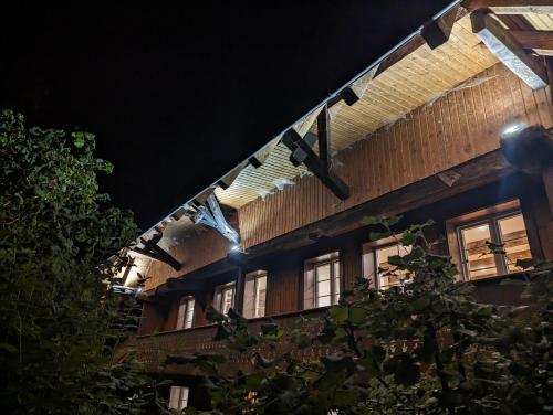 a building with lights hanging from the side at night at Ferienwohnung im Historischen Schwarzwaldhaus in Wieden