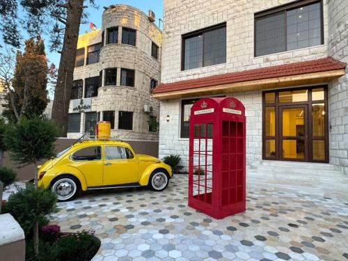 a yellow car parked next to a red phone booth at 6/ Antica jabalal-lwebdeh in Amman