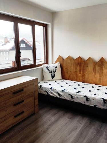 une chambre avec un lit, une commode et une fenêtre dans l'établissement Gîte Papillon 6 à14 personnes - Jacuzzi, à Gérardmer