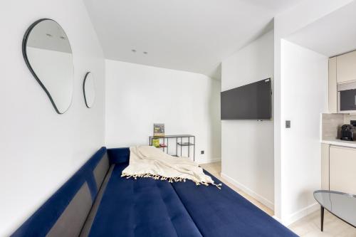 uma grande cama azul num quarto com um espelho em 1 Bedroom near Le Bon Marché em Paris