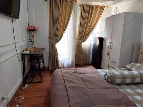 une chambre avec un lit, une table et une fenêtre dans l'établissement Apartement Podomoro golf view exit toll cimanggis, à Bogor