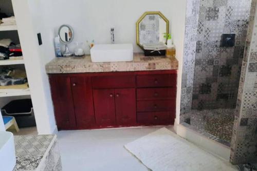 a bathroom with a red sink and a shower at Cozy family house with pool in Atenas