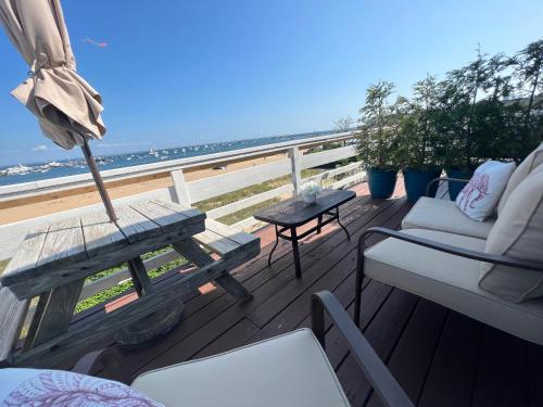 a balcony with a couch and a table and the beach at Lotus Provincetown in Provincetown