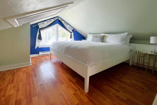 a bedroom with a large white bed with a window at Lotus Provincetown in Provincetown
