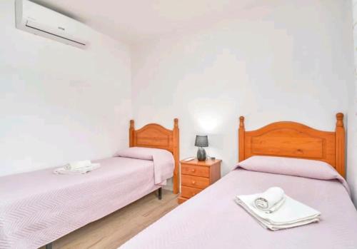 two beds in a room with white walls at La casita de Sergio in Frigiliana