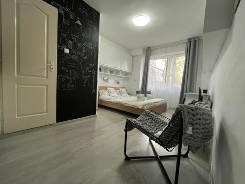 a room with a chair and a bed and a door at Central Park Studio in Cluj-Napoca