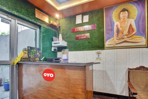 a bar with a picture of a buddha on the wall at OYO Flagship 81231 Urmila Guest House in Bodh Gaya