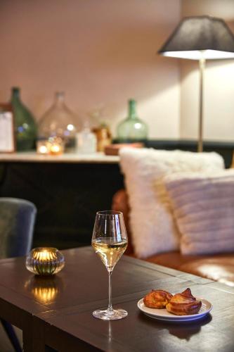a glass of wine and a plate of food on a table at La Flambée in Sennecey-lès-Dijon