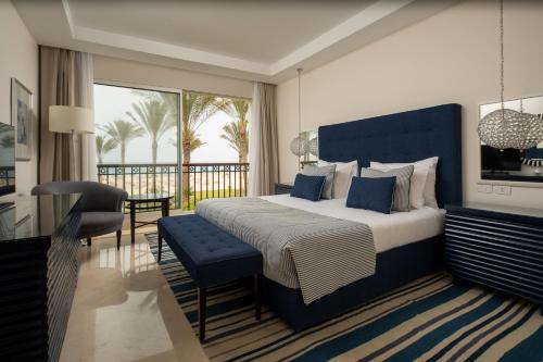 um quarto com uma cama grande e uma cabeceira azul em Jaz Crystal, Almaza Bay em Marsa Matruh