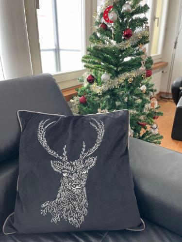 a pillow with a deer on it next to a christmas tree at Joe's Apartment am Bolgen in Davos