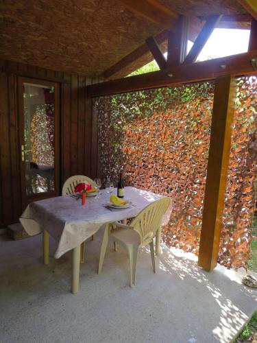 une table et des chaises assises sur une terrasse dans l'établissement Petit chalet cosy Sarlat, à Sarlat-la-Canéda