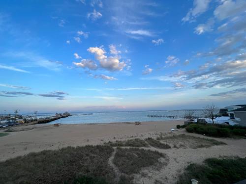 a beach with a cloudy sky and the ocean at Lotus Provincetown in Provincetown