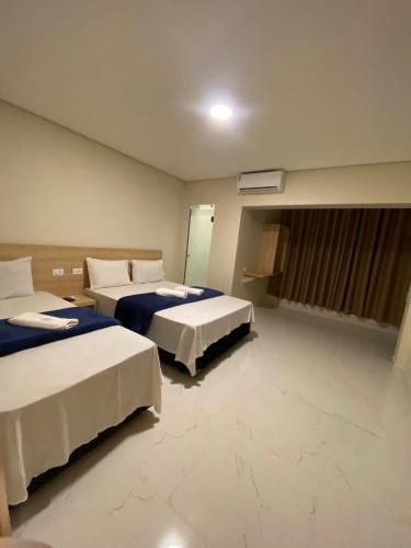 a hotel room with two beds and a window at Hotel Flex Tatuapé in Sao Paulo