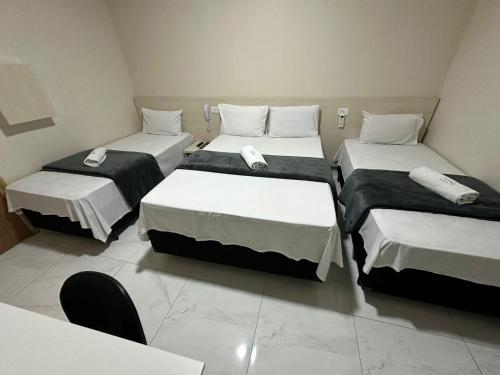 a room with three beds with phones on them at Hotel Flex Tatuapé in Sao Paulo