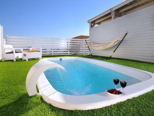 a swimming pool with two glasses of wine at לה פאצה - בריכה פרטית in Had Nes