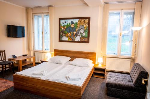 a bedroom with a bed and a couch and a chair at Apartments U Švejků in Prague