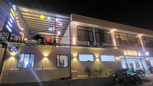 a building with motorcycles parked in front of it at night at Ha Giang Loop Rabbit Hostel & Tours in Ha Giang