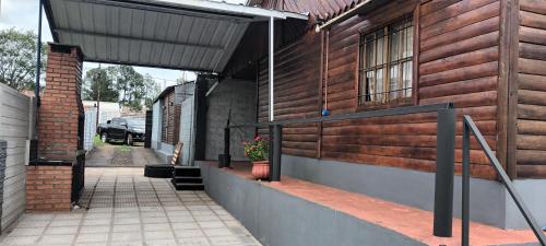 um edifício de tijolos com um alpendre com um vaso de plantas em Cabañas niño9 em Villa Dolores