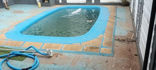 una piscina de agua con una manguera en el suelo en Cabañas niño9 en Villa Dolores