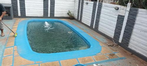 a pool of water in a backyard with a person using a hose at Cabañas niño9 in Villa Dolores