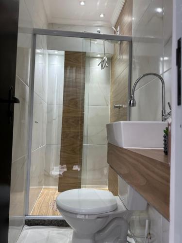 uma casa de banho com um WC, um lavatório e um chuveiro em Flat Restinga em Arraial do Cabo