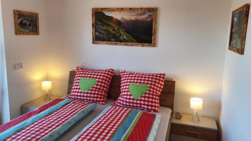 a bedroom with two beds with red and white pillows at Ferienwohnungen**** Sophie & Luca in Bad Grönenbach