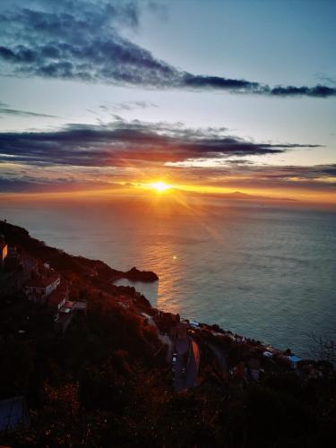 a sunset over the ocean with the sun setting at Otium Relais in Furore