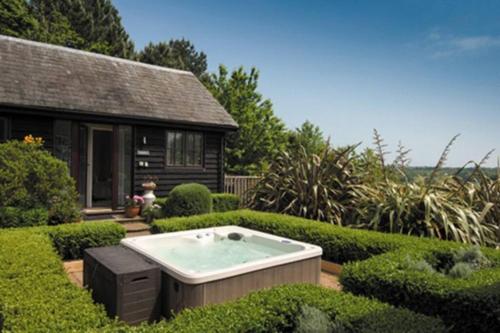 a hot tub in the middle of a garden at Blackthorn is a luxurious, rural retreat for two. in Icklesham