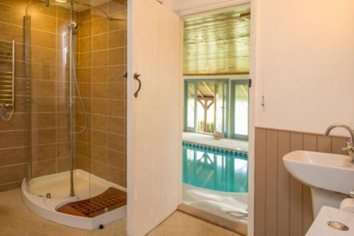 a bathroom with a shower and a sink and a tub at Blackthorn is a luxurious, rural retreat for two. in Icklesham