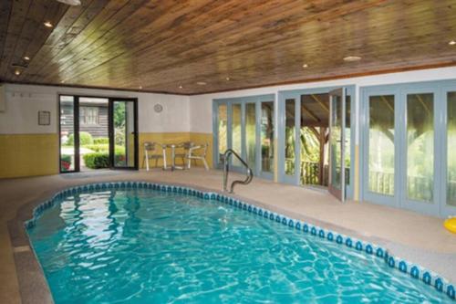 a large swimming pool in a house with a ceiling at Blackthorn is a luxurious, rural retreat for two. in Icklesham