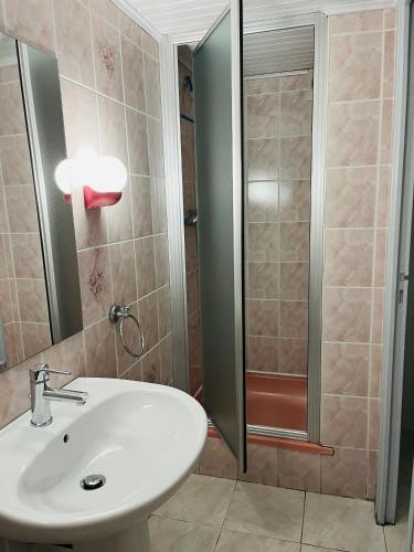 une salle de bain avec un lavabo et une douche dans l'établissement La Ligonne, à Marillac