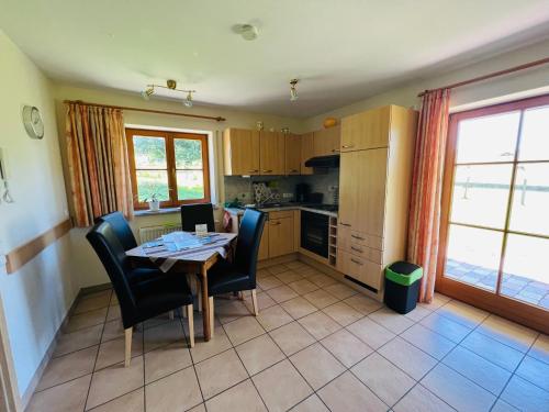 a kitchen with a table and chairs and a kitchen with a table and chairsktop at Ferienwohnungen Britta Heim in Oberstaufen