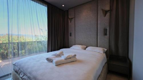 1 dormitorio con 1 cama grande y toallas. en Velour Hotel Spa Restaurant, en Sakarya