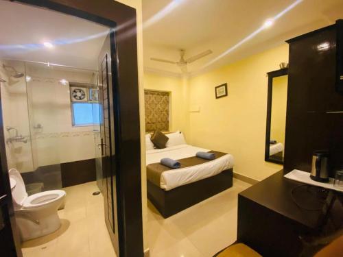 a bathroom with a bed and a toilet in a room at Rio Classic, Top Rated & Most Awarded Property in Haridwar in Haridwār