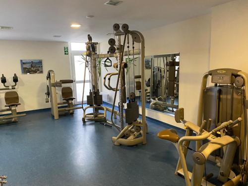 einen Fitnessraum mit mehreren Laufbändern und einem Spiegel in der Unterkunft FeWo Waldsee mit Pool und Sauna inklusive in Sankt Englmar